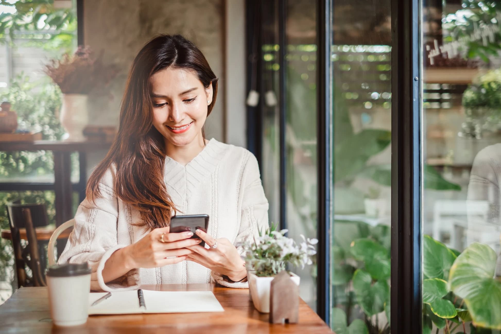 Young woman using smart phone money transfer in coffee shop cafe