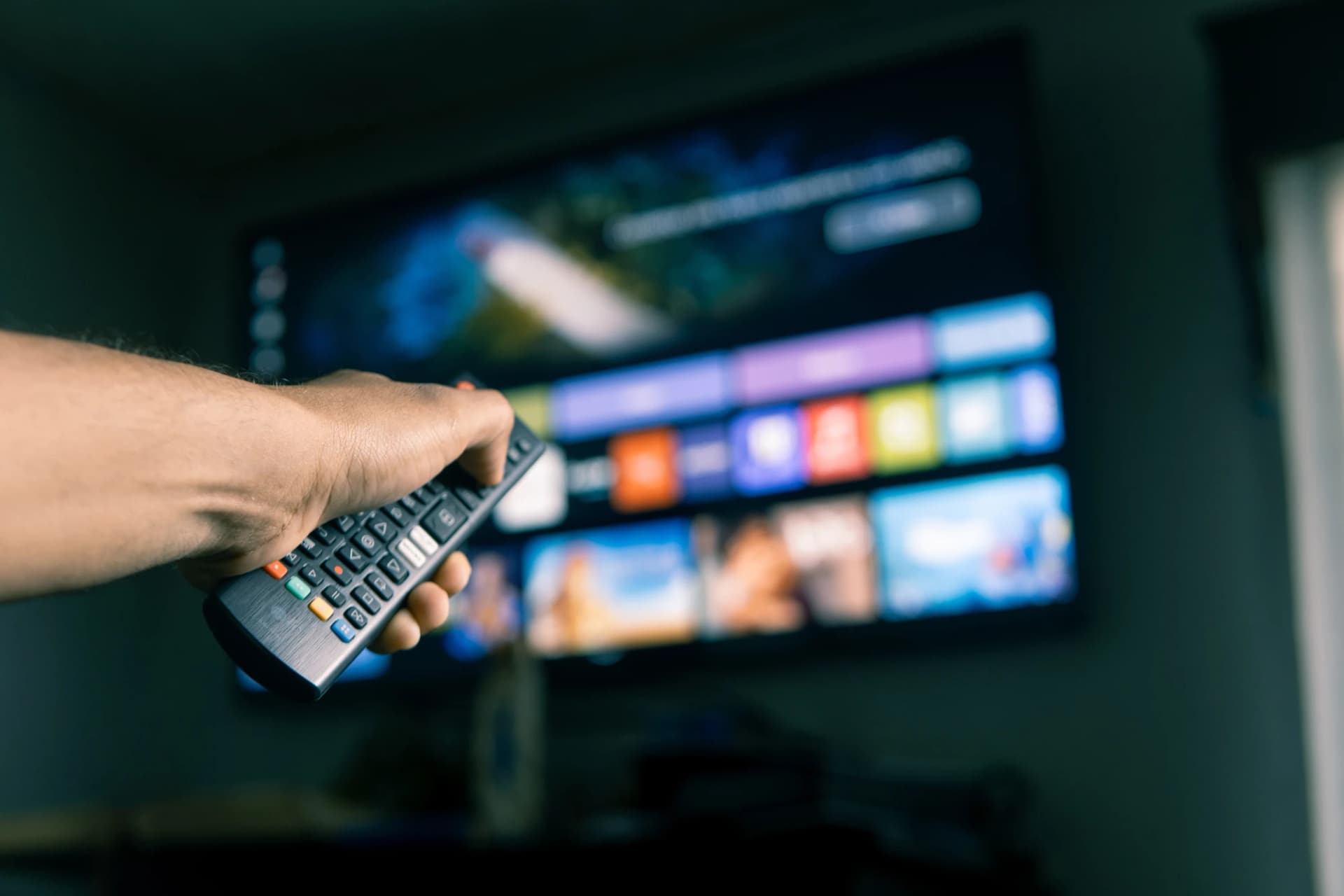 Man using remote control to choose streaming platform program on smart tv Man using remote control to choose streaming platform program on smart tv